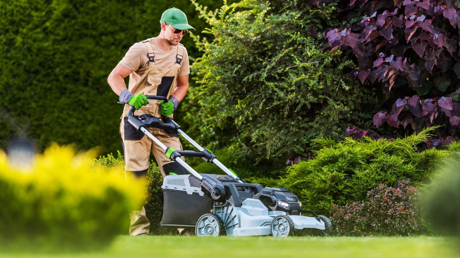 Professional mowing a green residential lawn